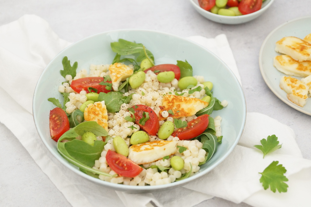 Parelcouscous met kerstomaatjes, edamame boontjes, rucola en haloumi gezonde vegetarische lunch