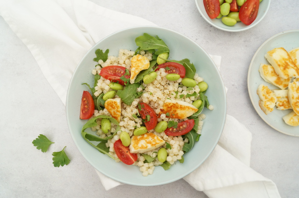 Parelcouscous met kerstomaatjes, edamame boontjes, rucola en haloumi gezonde vegetarische lunch