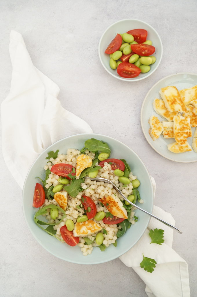 Parelcouscous met kerstomaatjes, edamame boontjes, rucola en haloumi gezonde vegetarische lunch